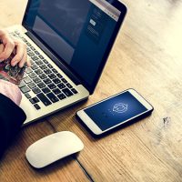 Hands with tattoo on laptop and mouse